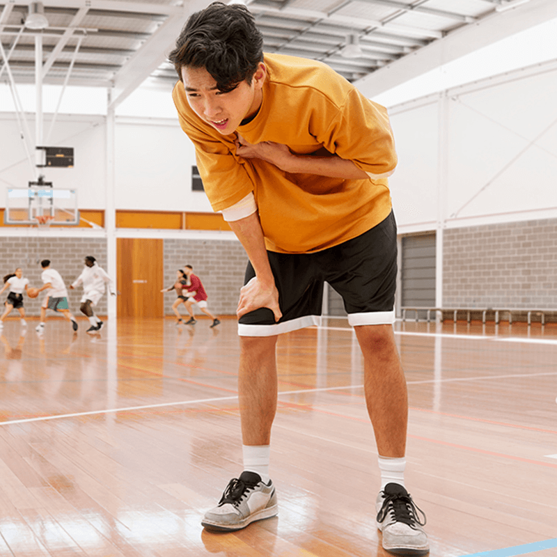 A young woman in her living room preparing to go outside by protecting her skin with sunglasses, sunscreen a hat