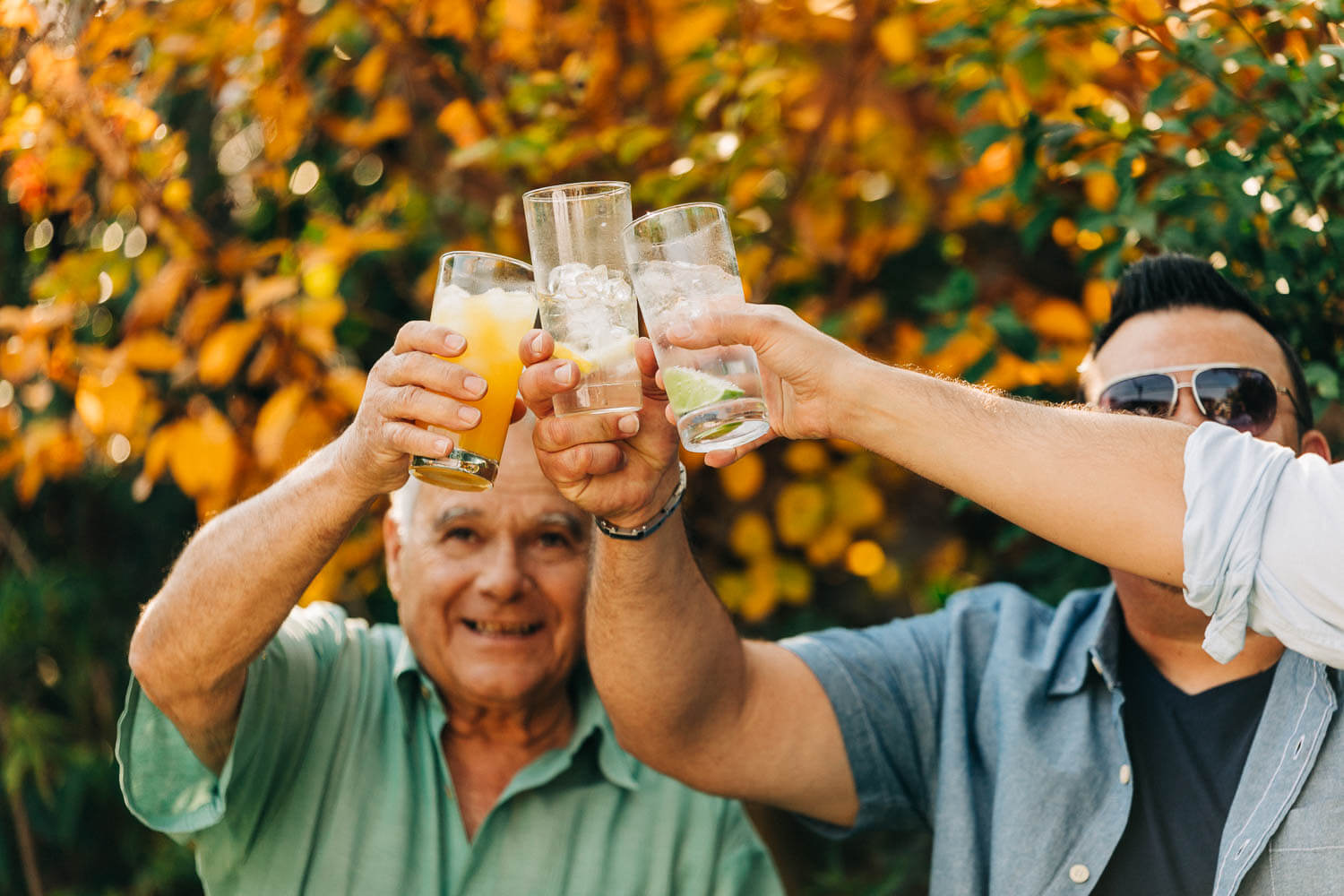 A group of men drinking giving cheers with their water and orange juice glasses