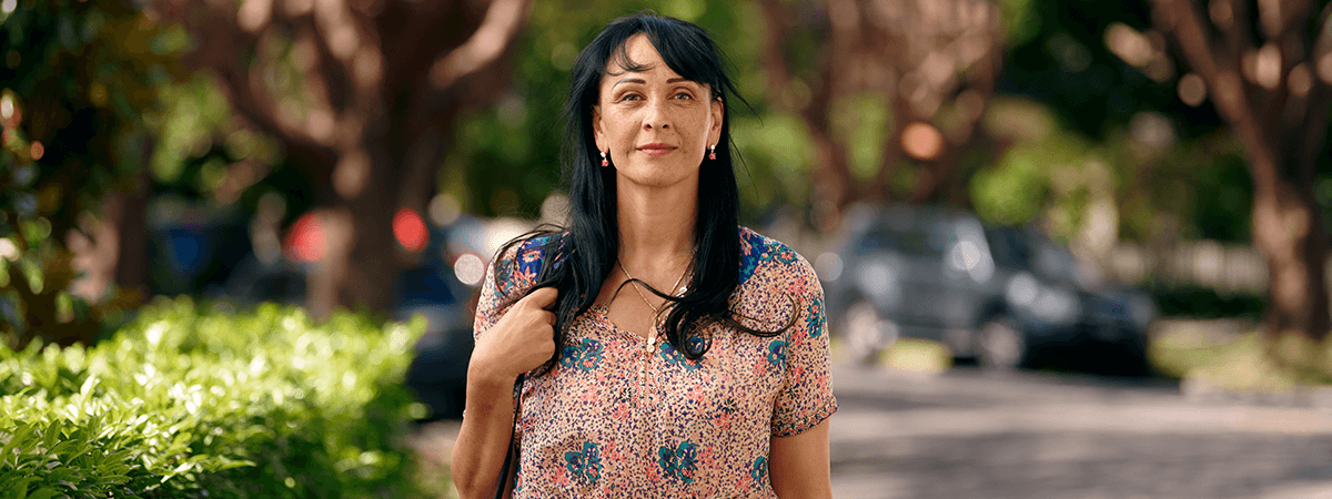 A woman carrying her handbag as she walks down the street.
