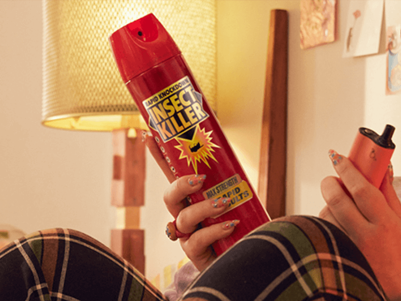 A young woman in her living room preparing to go outside by protecting her skin with sunglasses, sunscreen a hat