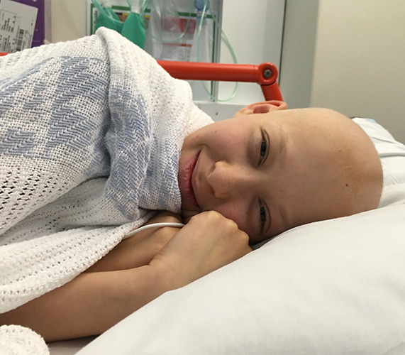 Ruby lying in a hospital bed during her treatment